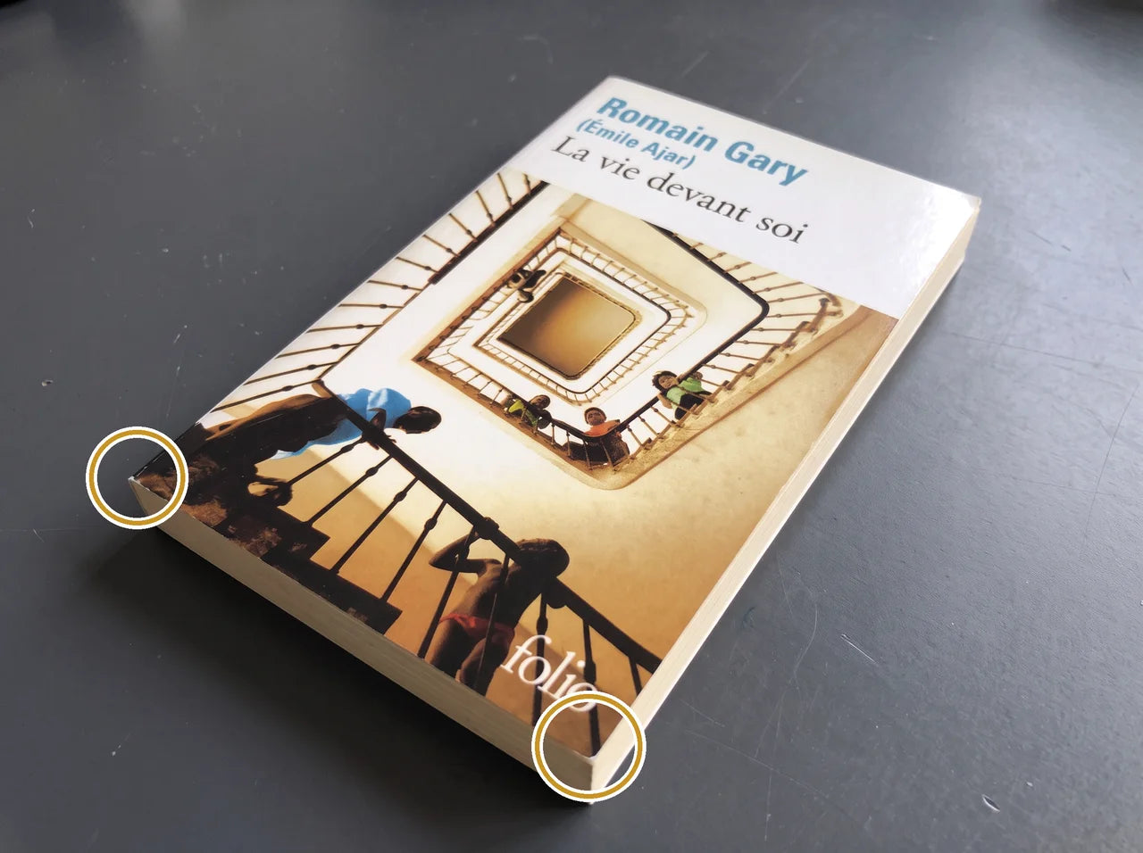 Livre de poche aux coins nets, sans pli visible ; les cercles repèrent les coins préservés.